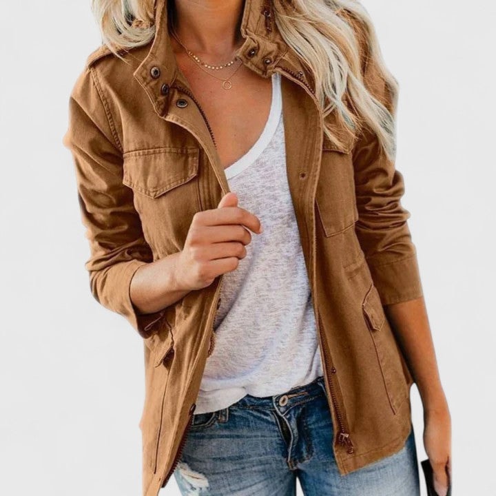 Chaqueta casual marrón con cuello alto, cierre delantero y bolsillos frontales, llevada abierta con vaqueros.