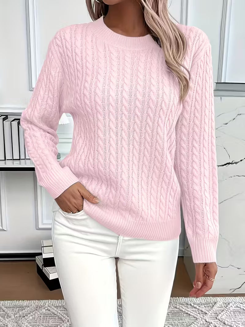 Jersey rosa claro de punto calado con cuello redondo, mangas largas y bajo acanalado sobre pantalón blanco.