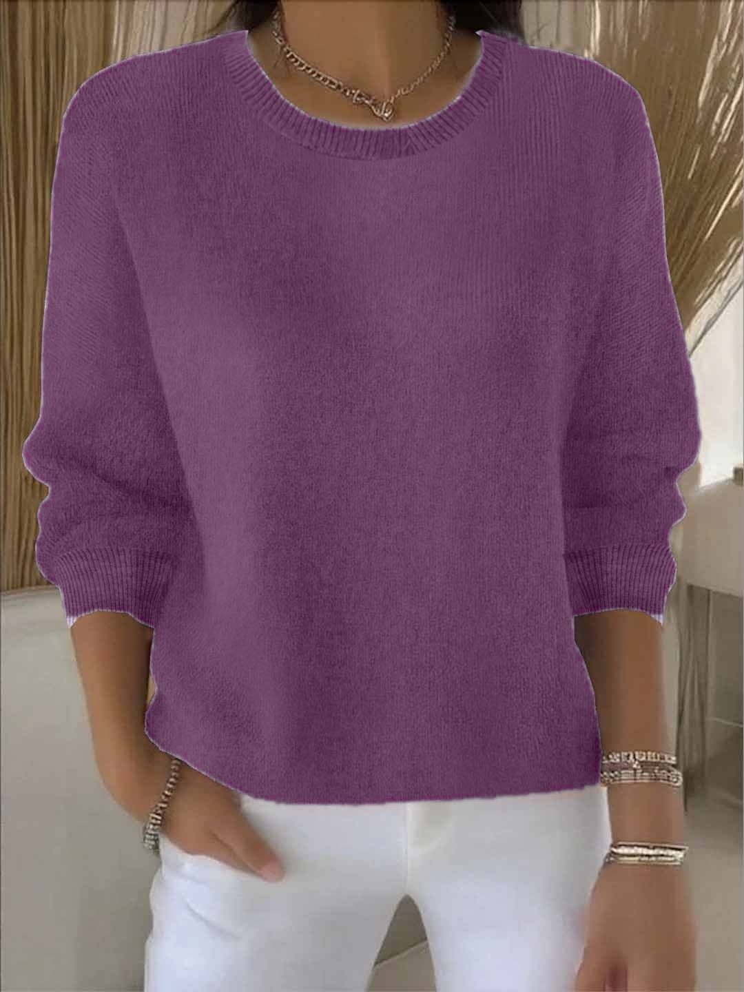 Jersey morado de mangas largas y silueta relajada, con cuello redondo y bajo curvado.