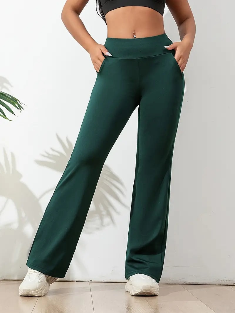 Pantalón deportivo verde oscuro de tiro alto y corte amplio, mostrado con las manos en los bolsillos laterales.