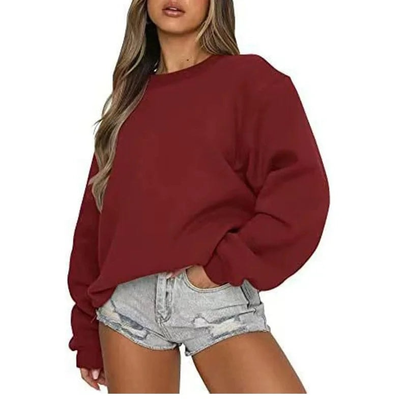 Sudadera oversize burdeos de corte amplio, con puños ajustados y shorts vaqueros claros.