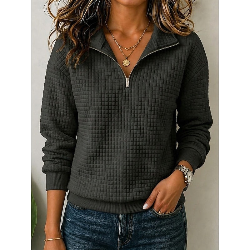 Sudadera texturizada negra con media cremallera abierta, cuello elevado, mangas largas y acabados acanalados.
