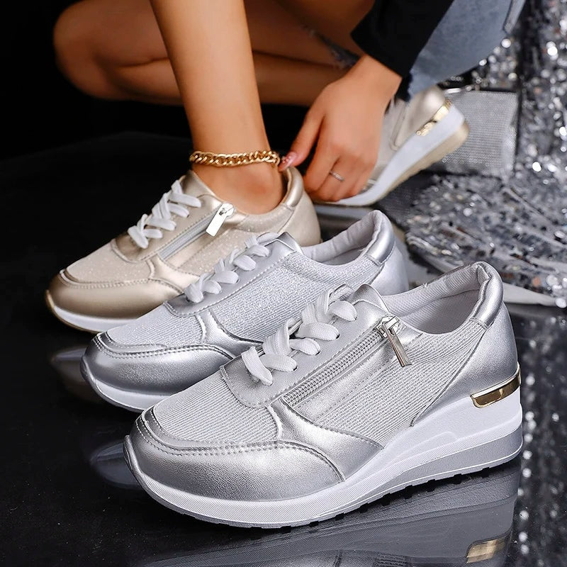 Par de zapatillas plateadas de plataforma en primer plano junto a otra zapatilla color champán, destacando los cordones y las cremalleras laterales.