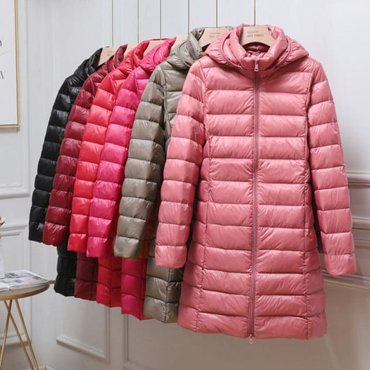 Abrigos acolchados largos con capucha en varios colores, con un modelo rosa al frente.