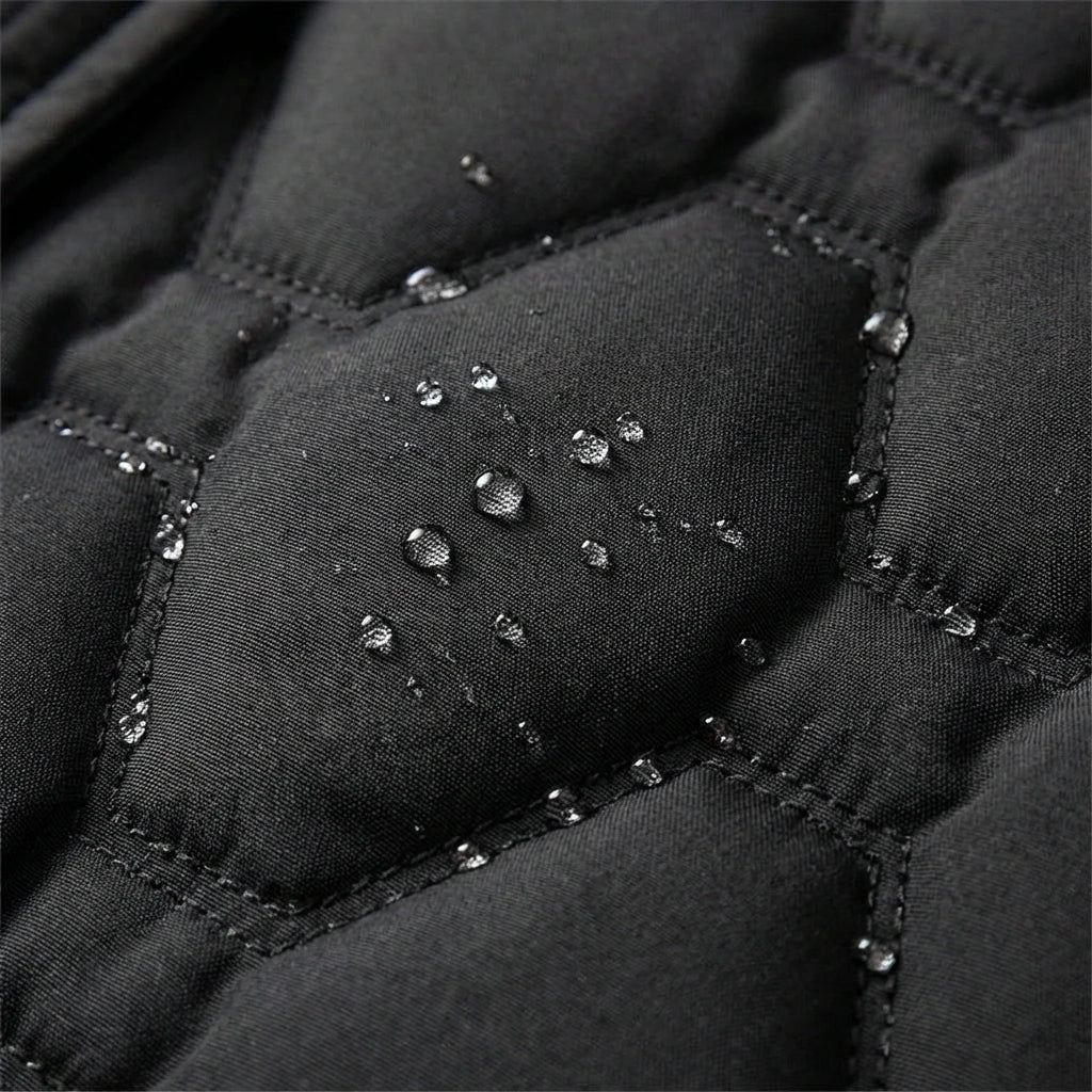 Primer plano del acolchado negro con gotas de agua sobre el panel central y las costuras.