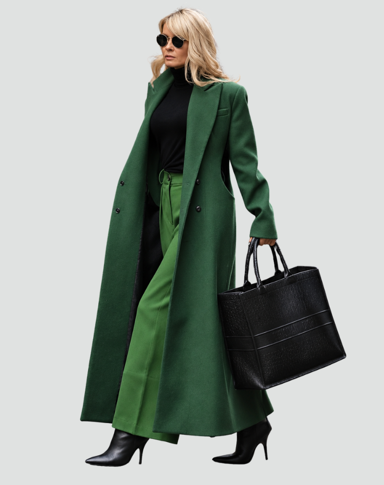 Vista lateral de un abrigo largo verde oscuro con solapas, combinado con pantalón a juego, botas de tacón y bolso estructurado.