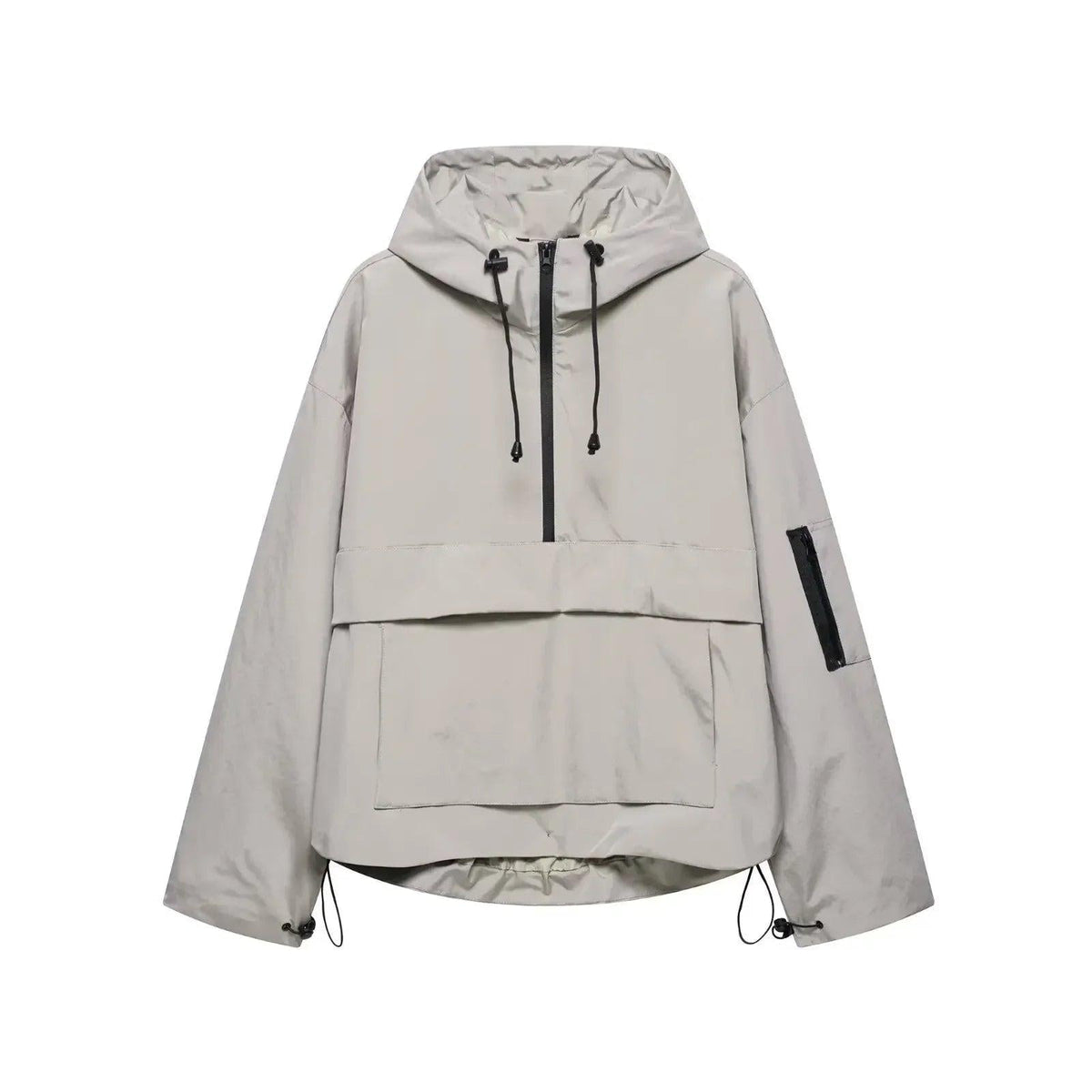 Anorak gris claro de corte amplio, mostrado de frente con capucha ajustable, panel delantero superpuesto, bolsillo frontal y bajos regulables.