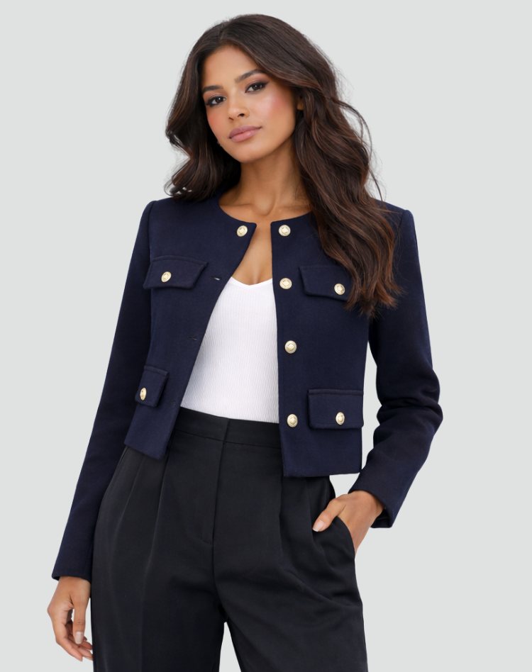 Blazer azul marino abierto que deja ver una prenda blanca, con solapas de bolsillo y botones dorados.