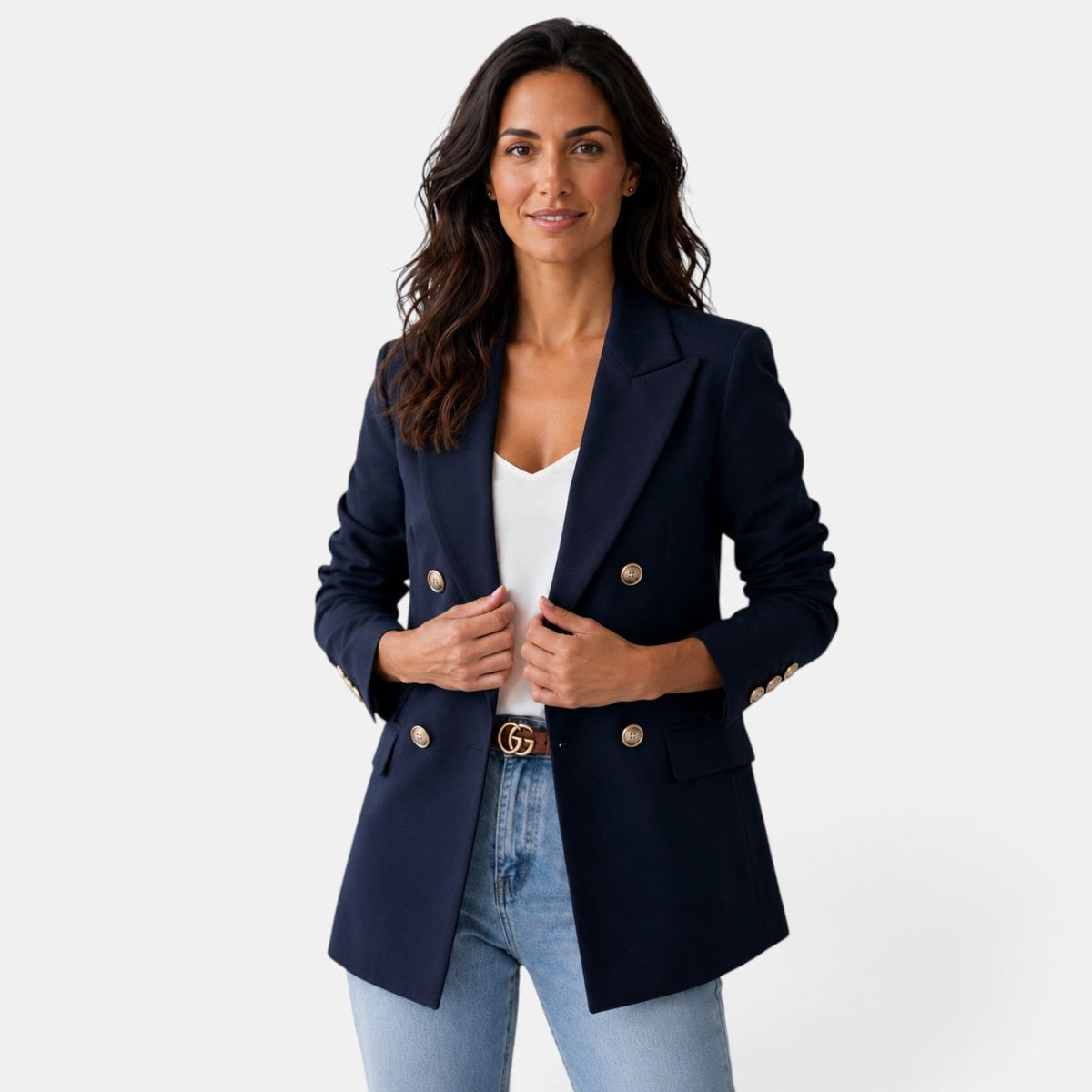 Blazer azul marino de mujer de doble botonadura, con solapas marcadas, mangas largas y bolsillos delanteros, llevado con vaqueros.