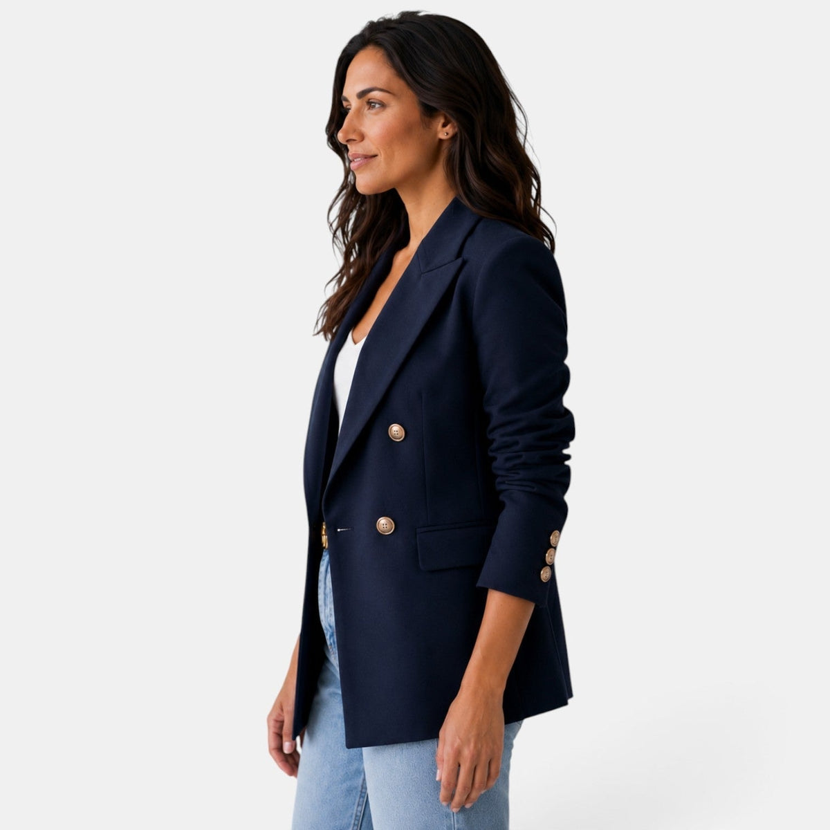 Vista lateral del blazer azul marino, con solapa definida, botones frontales, bolsillo con tapa y botones en el puño.