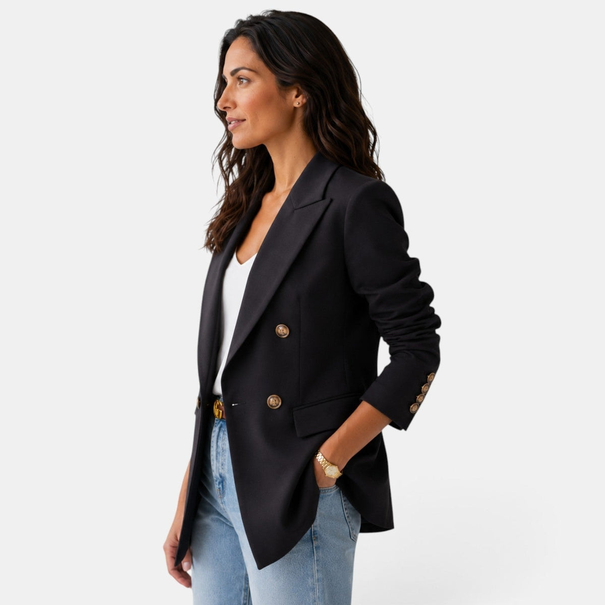 Vista lateral del blazer negro, que muestra la solapa, el bolsillo delantero con tapa y los botones decorativos del puño.