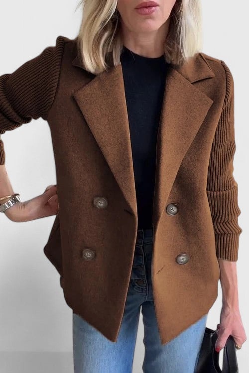 Blazer entallada marrón de doble botonadura y mangas acanaladas, combinada con camiseta negra y vaqueros.