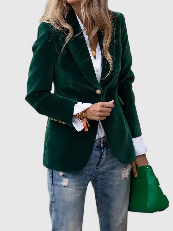 Blazer entallado verde oscuro con cierre de un botón y solapas clásicas, llevado sobre una camisa blanca.