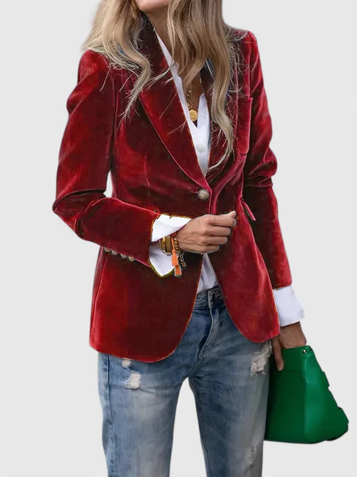 Blazer entallado rojo de un botón con solapas, combinado con camisa blanca y vaqueros desgastados.
