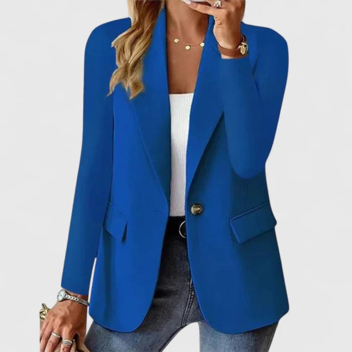 Blazer entallado azul intenso de un botón, con solapas definidas y bolsillos con solapa, sobre una camiseta blanca y vaqueros.