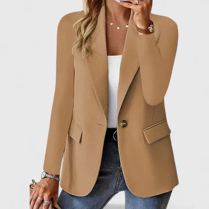 Blazer entallado color camel de un botón, con cierre frontal, solapas y bolsillos con solapa, llevado sobre una camiseta blanca.