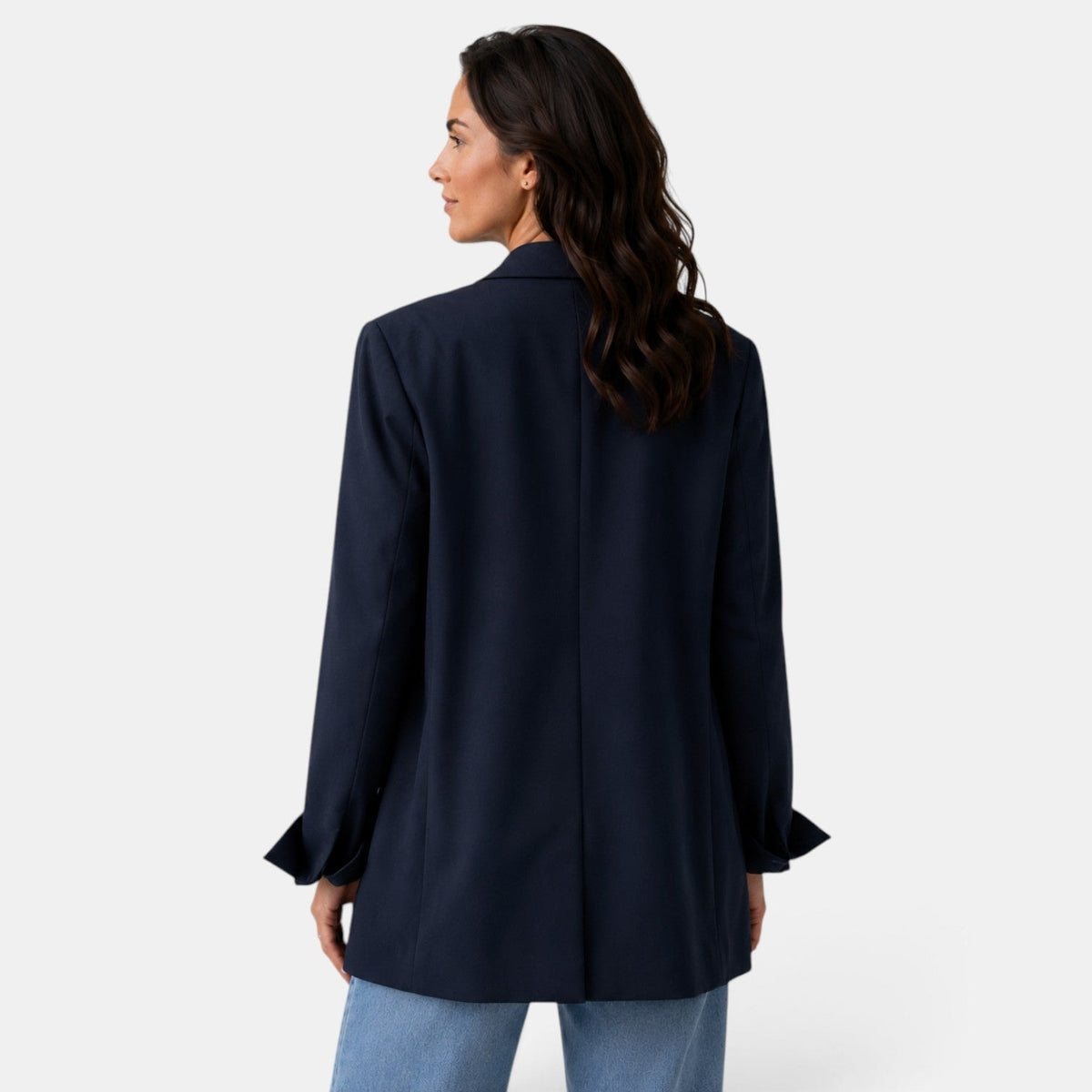 Vista trasera del blazer oversize azul marino, con costura central, corte amplio y puños vueltos visibles.