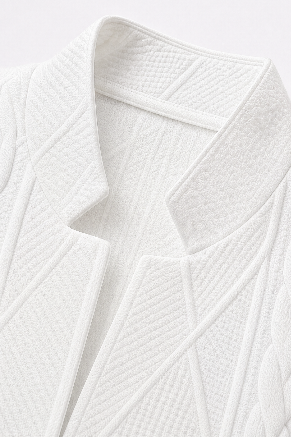 Detalle del cuello alto estructurado y las solapas interiores del blazer blanco.