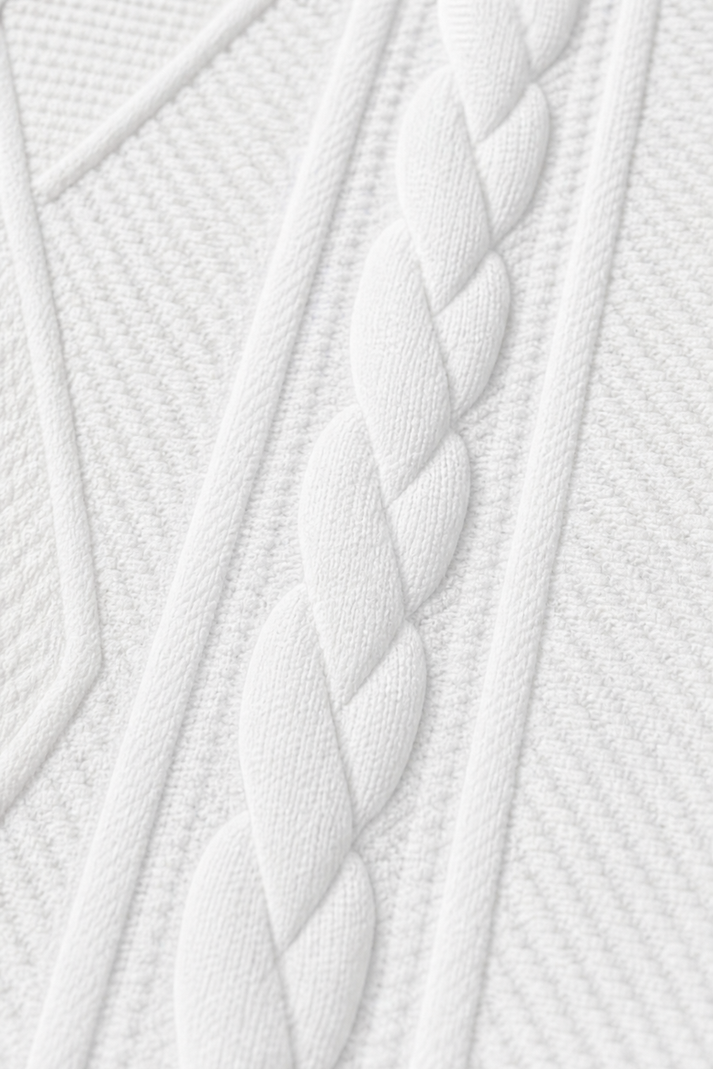 Primer plano del relieve trenzado que recorre verticalmente el blazer blanco.