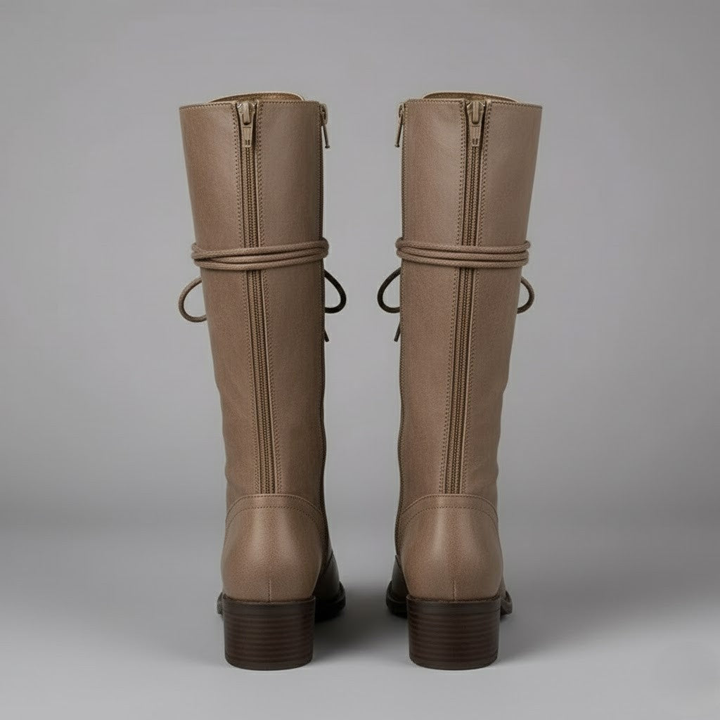 Parte trasera de un par de botas altas beige, con cremalleras verticales y tacones de bloque.