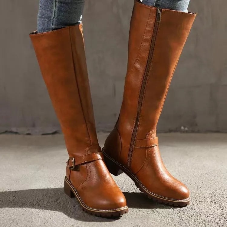 Botas altas marrón cobrizo con cremallera lateral, hebilla decorativa y tacón bajo, vistas desde el frente.