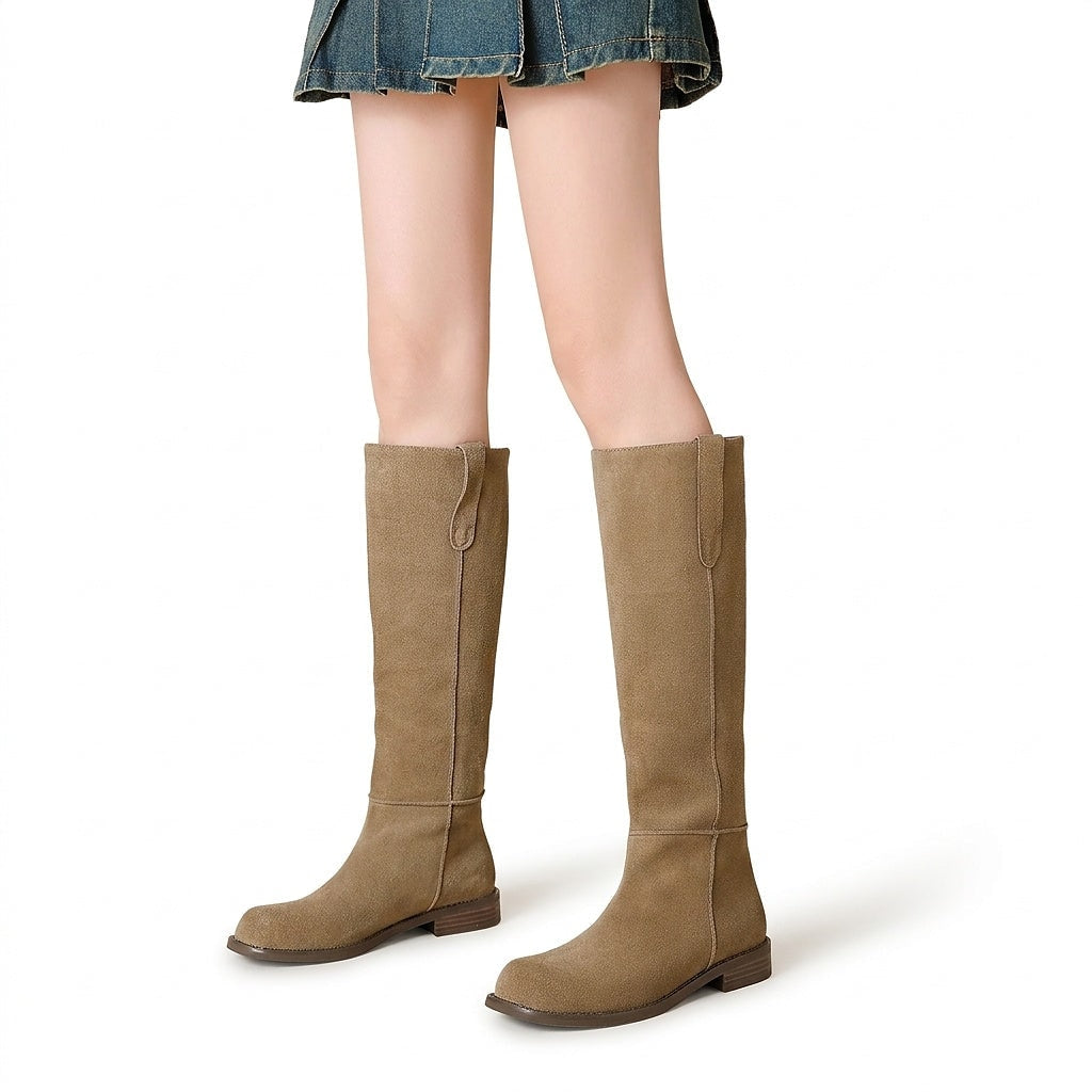 Botas altas de mujer en tono marrón claro, mostradas de frente y perfil con puntera redondeada, caña hasta la rodilla y suela plana.
