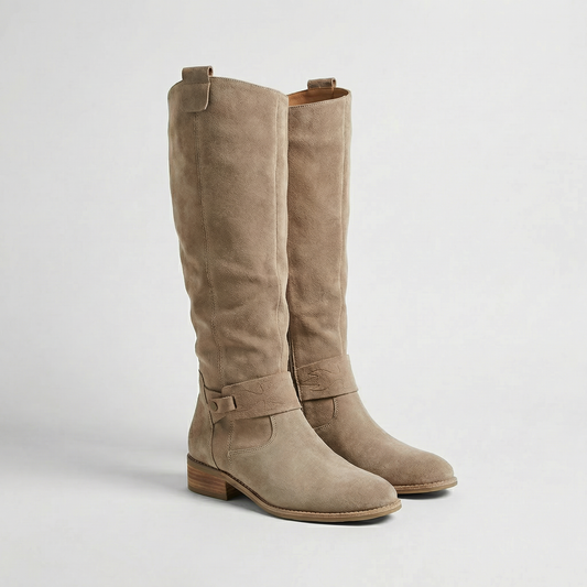 Botas altas de mujer en tono beige, mostradas en vista de tres cuartos, con tacón bajo y hebilla lateral.