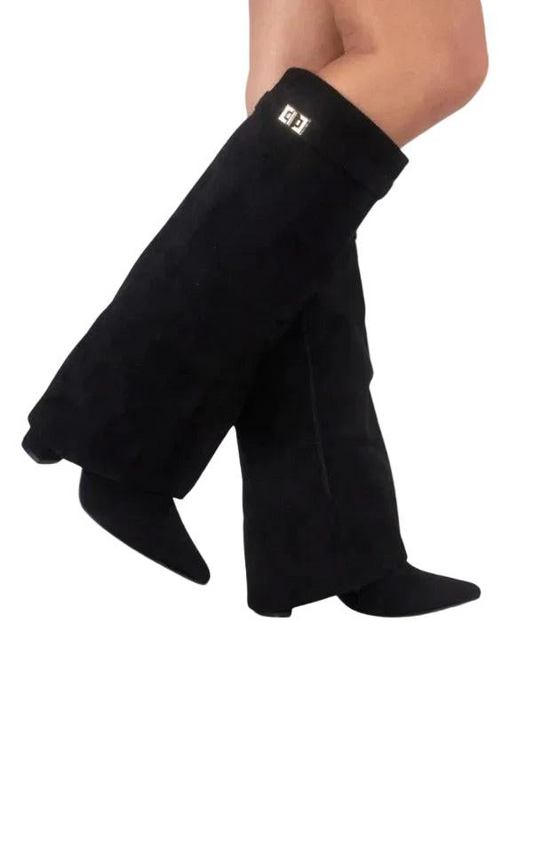 Botas altas negras de punta fina y tacón de bloque, mostradas de perfil mientras se cruzan las piernas.