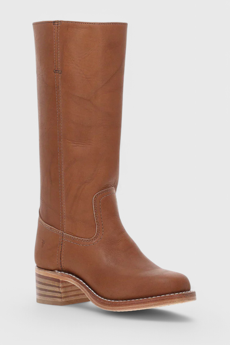 Bota alta marrón vista desde un ángulo frontal, con puntera redondeada, panel decorativo y tacón bajo.