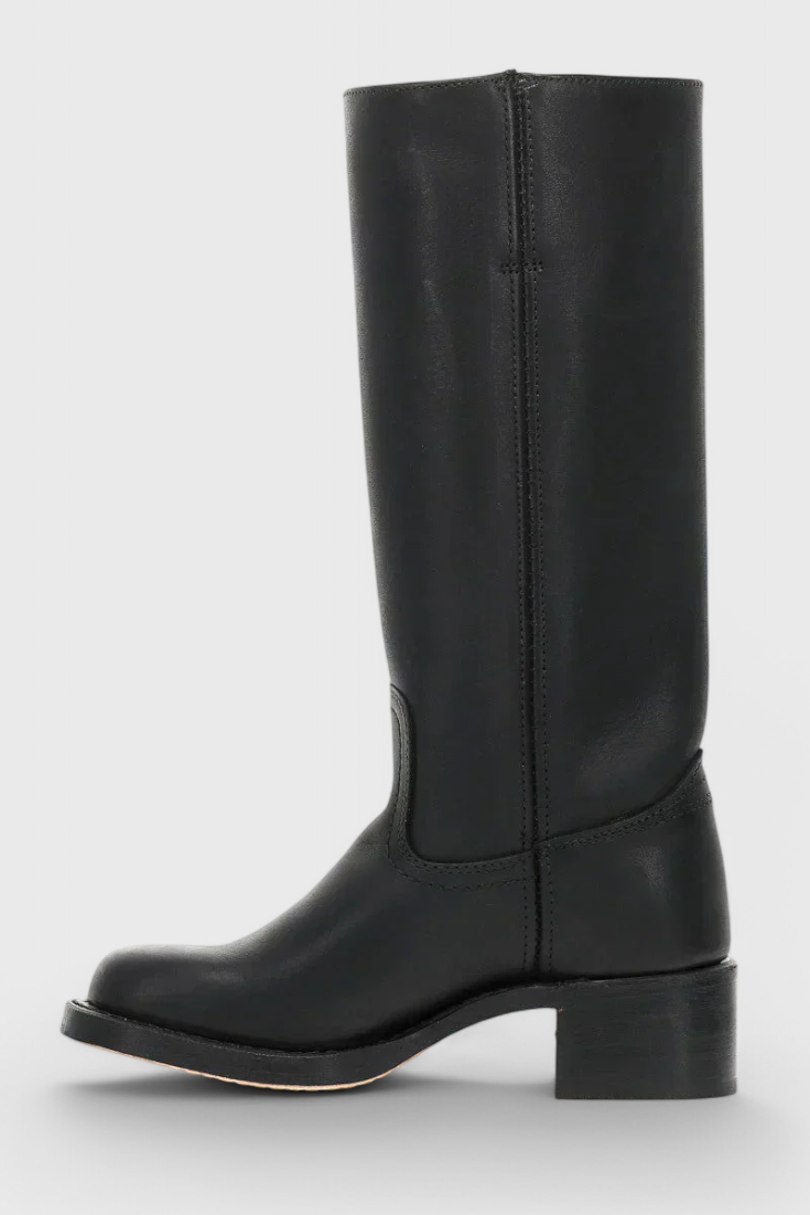 Bota alta negra en perfil lateral opuesto, mostrando la línea limpia de la caña y el tacón bajo.