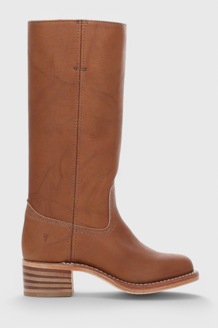 Bota alta marrón en perfil lateral, con caña recta, costura vertical y tacón bajo de capas horizontales.