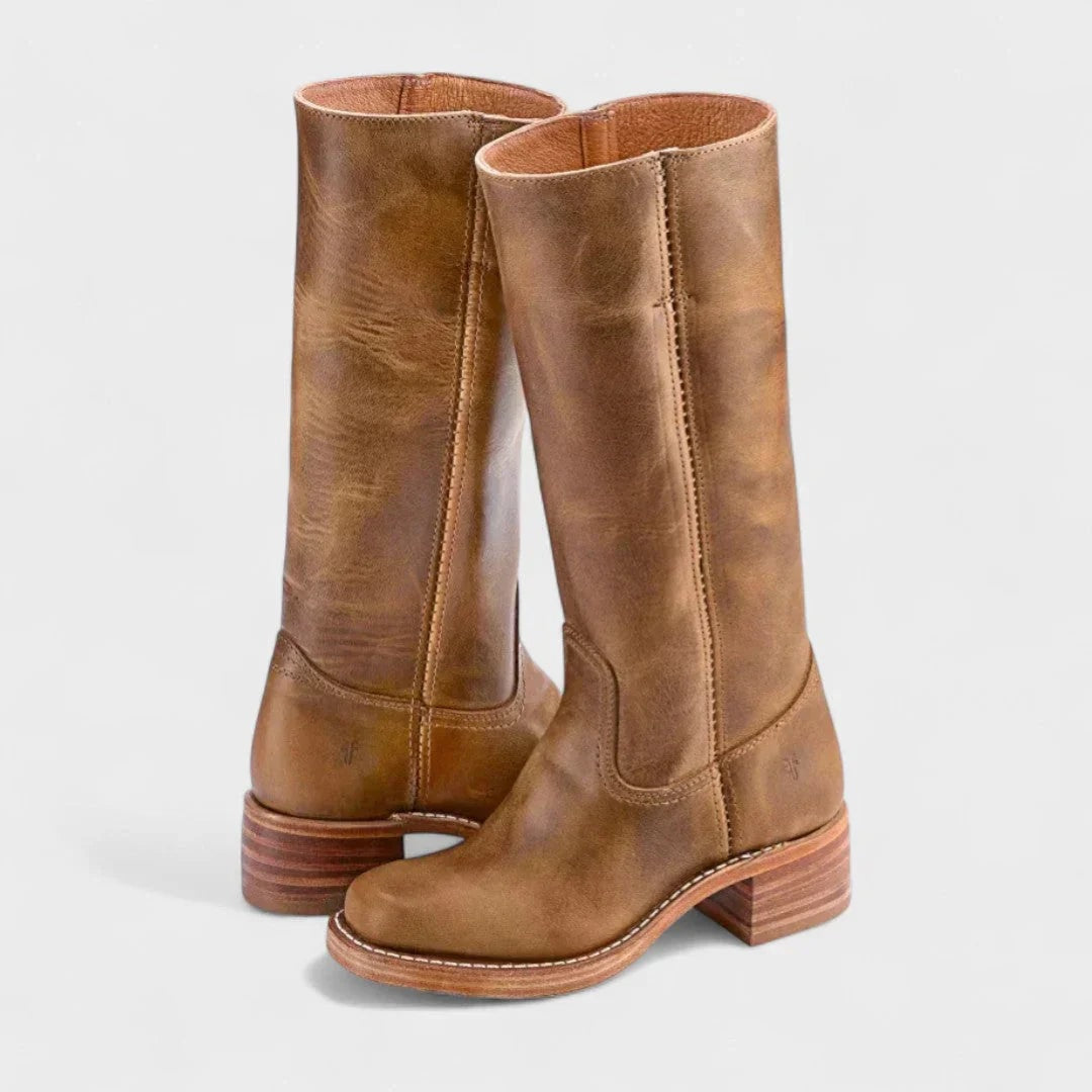 Botas altas en tono marrón claro con caña estructurada, paneles de costuras decorativas y suela con tacón bajo estratificado.