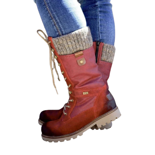 Botas de invierno en tonos rojizos con caña media de punto, cordones y detalles de ojales metálicos, mostradas sobre vaqueros.