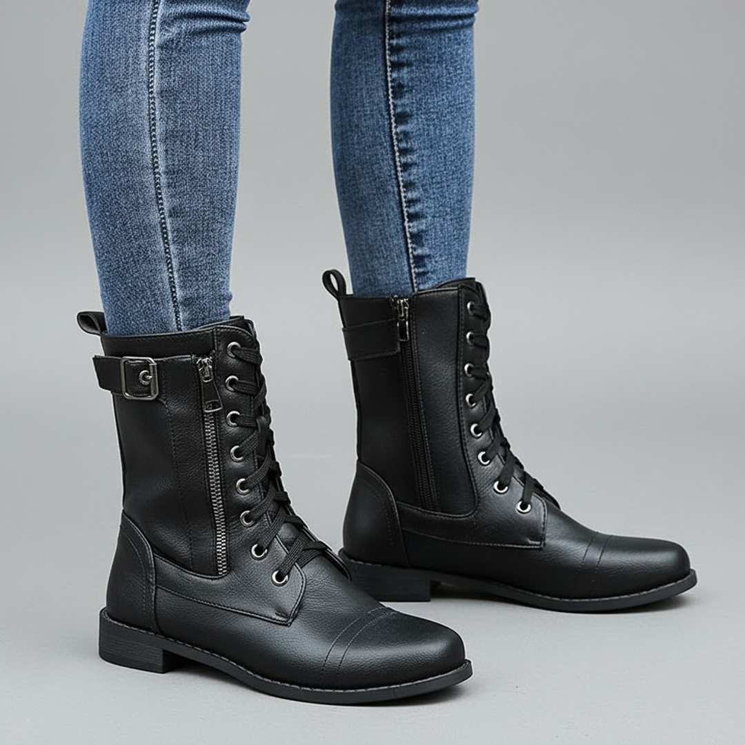 Botines negros combinados con vaqueros, vistos en ángulo, con cordones, cremallera lateral y puntera redondeada.