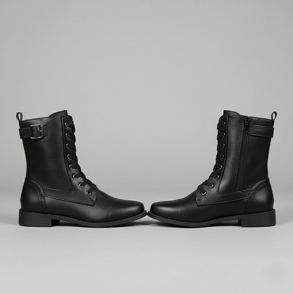 Botines negros enfrentados de perfil, mostrando sus cordones, cremalleras laterales y suela baja.