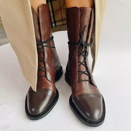 Botines marrones de caña media con cordones y punteras oscuras, combinados con un abrigo claro.