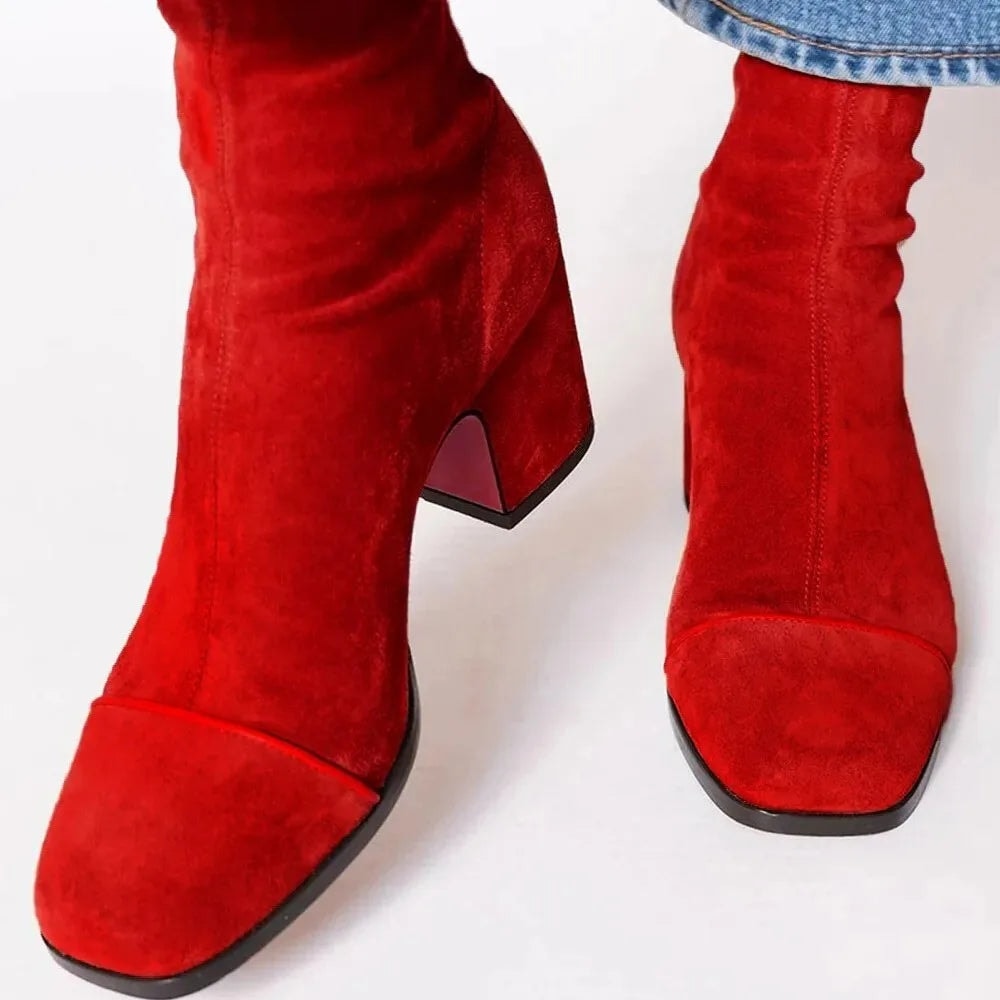 Botines rojos de tacón ancho con puntera cuadrada lisa, mostrados desde una vista frontal elevada.