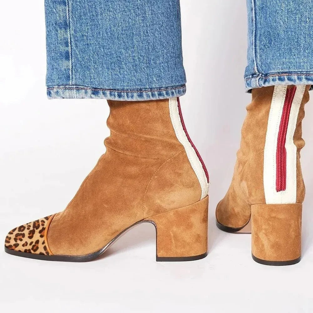 Botines camel de tacón ancho con puntera estampada de leopardo y cremallera trasera roja sobre una franja clara.