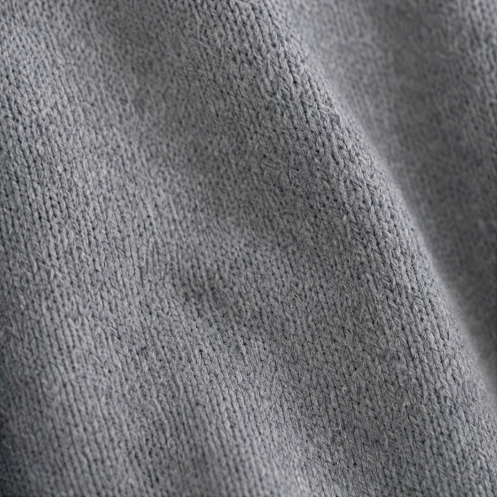 Detalle de cerca del tejido de punto gris del cárdigan.