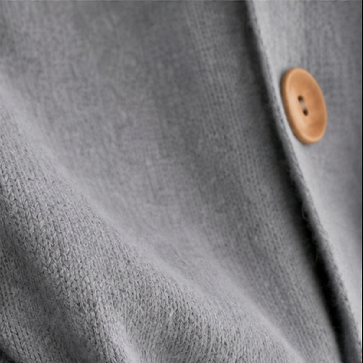 Detalle del borde frontal gris y uno de sus botones de madera.