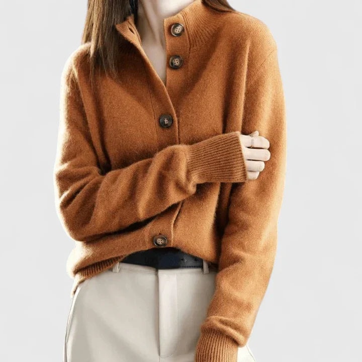 Cárdigan marrón con cuello elevado y botones frontales, llevado con pantalón claro.