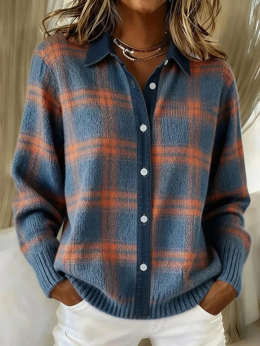 Cárdigan azul con estampado de cuadros en tonos naranjas, cuello camisero, botones frontales y puños acanalados, combinado con pantalón blanco.