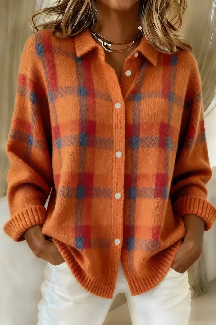 Cárdigan naranja con cuadros en tonos azul y rojizo, cuello camisero, botones claros y mangas rematadas con puños acanalados.