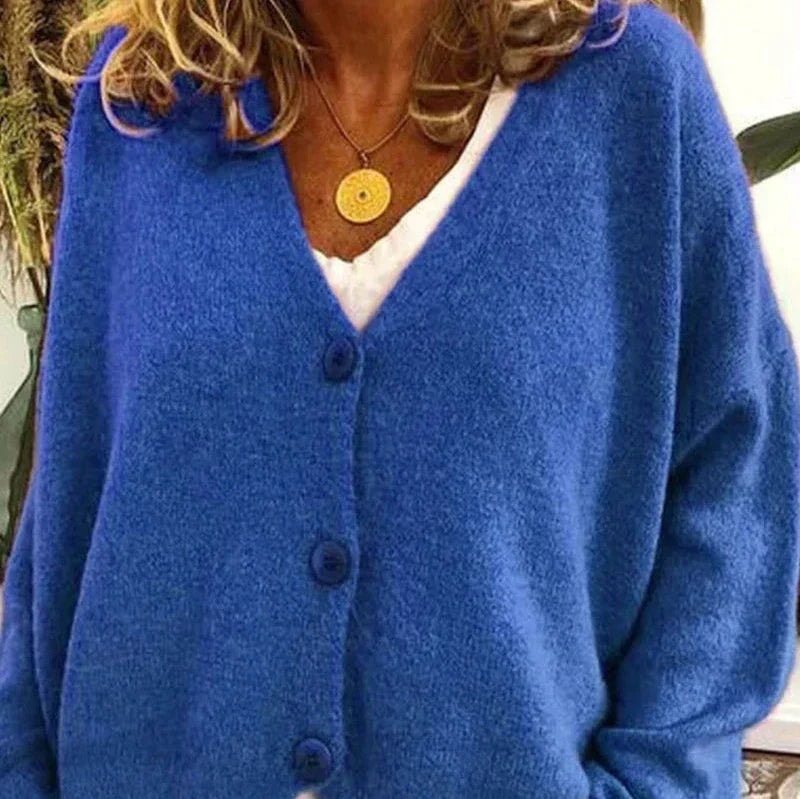 Cárdigan azul intenso de cuello en V, con botones a juego y corte cómodo sobre una camiseta blanca.