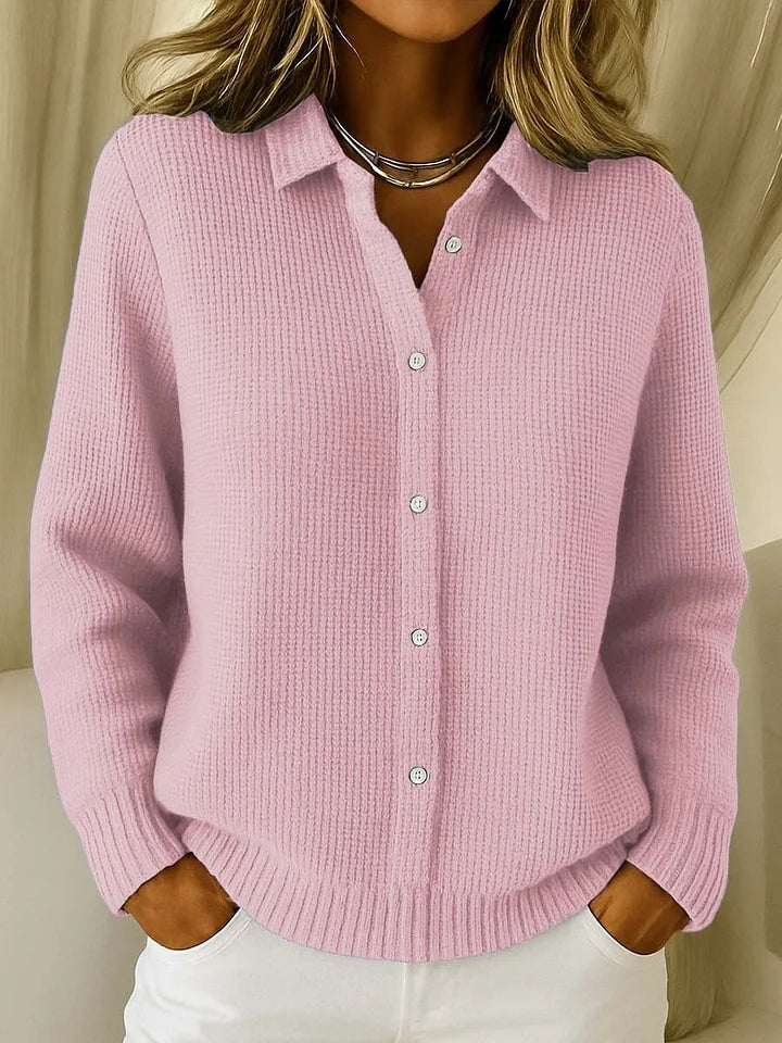 Cárdigan de punto rosa con cuello camisero y botones frontales, mostrado con un corte relajado y mangas largas.