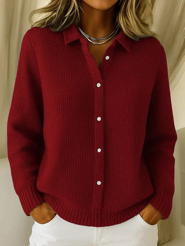 Cárdigan de punto burdeos con cuello camisero, cinco botones visibles y puños acanalados.
