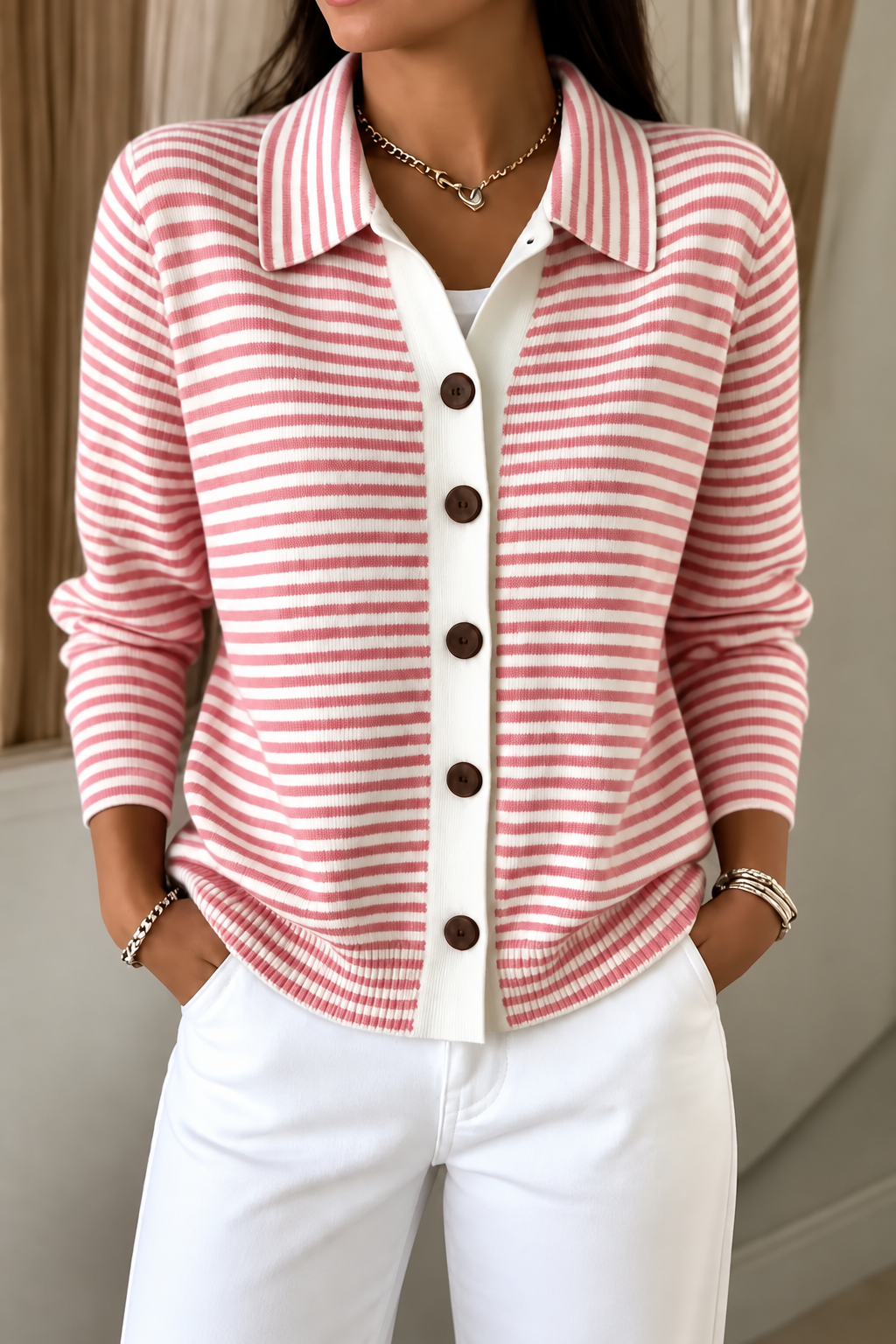 Cárdigan de rayas rosas y blancas abrochado, combinado con pantalón blanco.