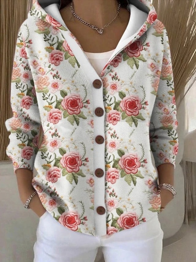 Cárdigan claro con capucha y botones, cubierto de un estampado floral de rosas en tonos rosados y hojas verdes.