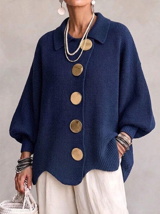 Cárdigan holgado azul marino con cuello, mangas amplias, cinco botones grandes y bajo ondulado, combinado con pantalones claros.