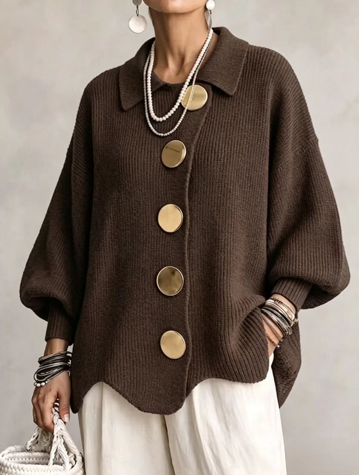 Cárdigan marrón oscuro con forma amplia, cuello clásico, mangas abullonadas y bajo curvado.